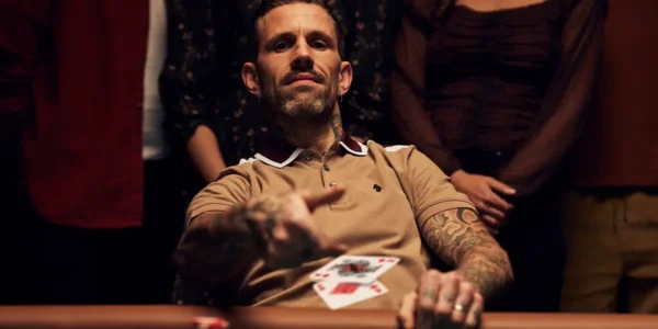 Poker player folding cards against a large river bet.