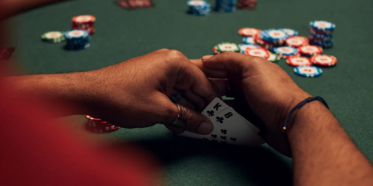 A poker player betting chips into a small multiway pot on a checked-down board.