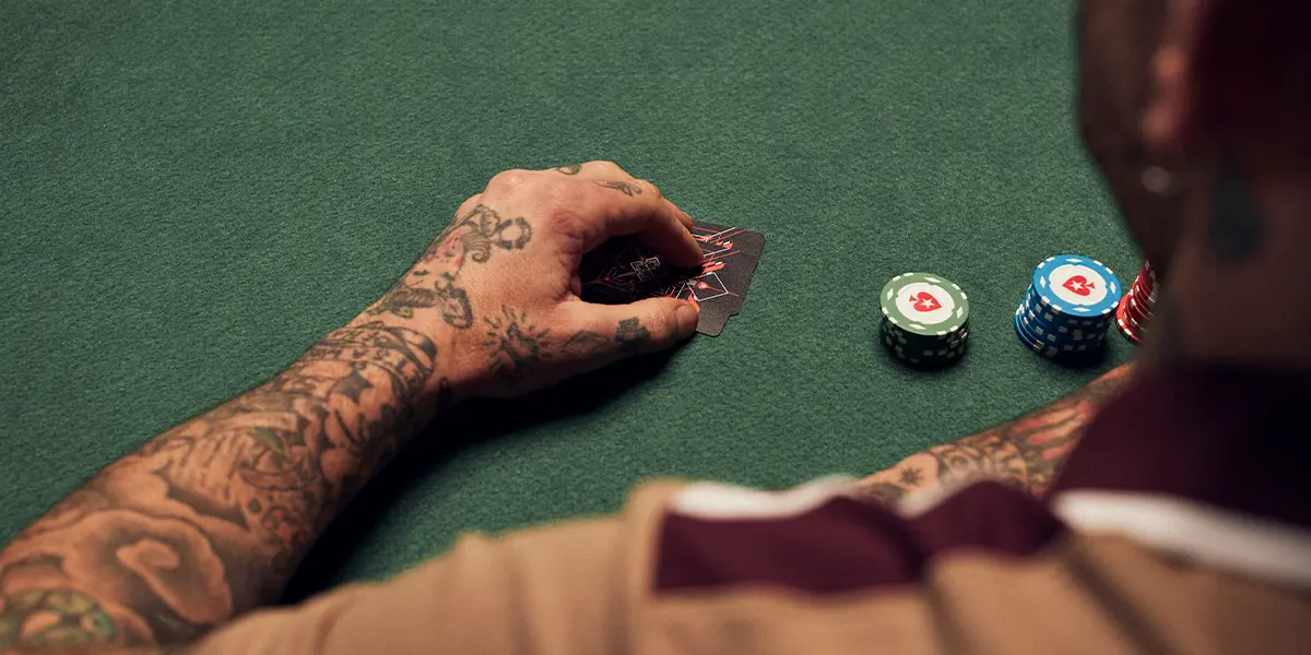 Player looking at hole cards before making a three-bet bluff in a Texas Hold’em hand.