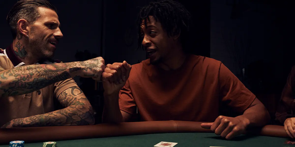 Two poker players fist-bumping at the table after a successful river bet