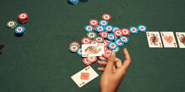 Close-up of poker chips already in the pot as a player considers whether to fold or commit against heavy aggression.