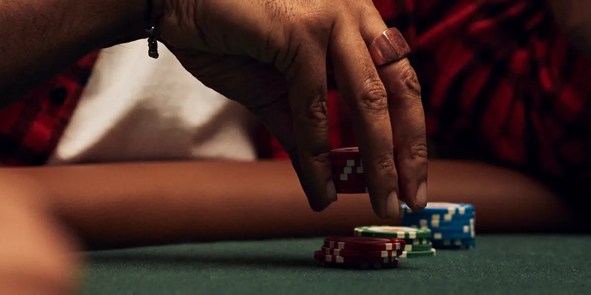 Reaching for chips — representing an aggressive 3-bet move in a cash game.