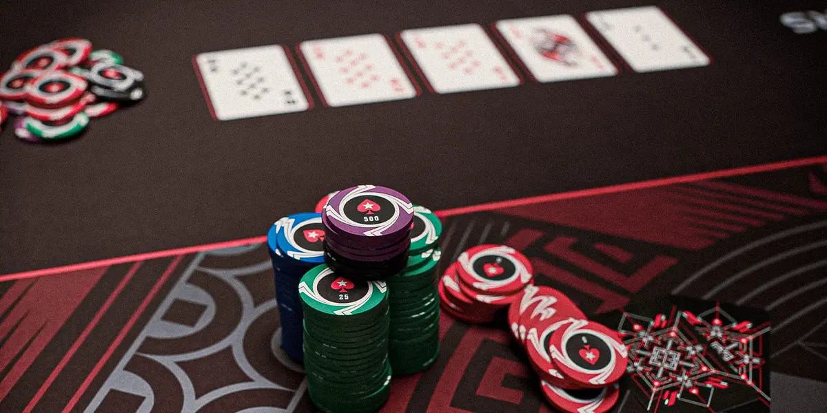 Large poker chip stack and community cards on a table.