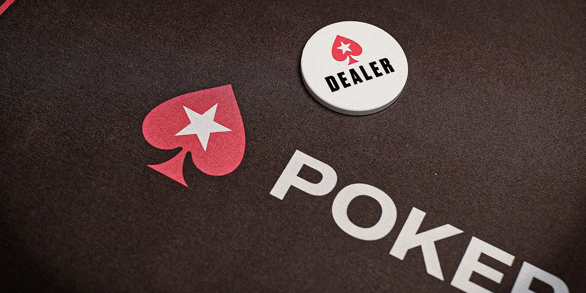 A white poker dealer button on a poker table felt.