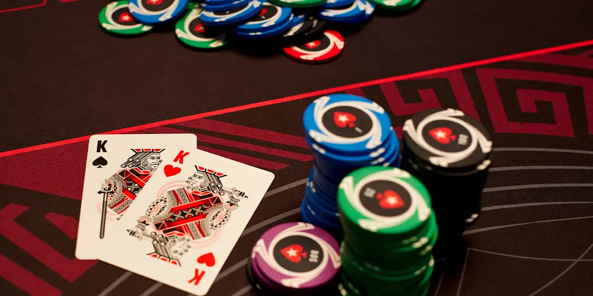 A pair of pocket kings and stacks of poker chips on a table.